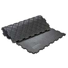 Svart pusselm�nstrad gummimatta med halks�ker yta, delvis upprullad 