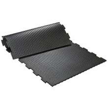 Svart pusselm�nstrad gummimatta med knottrig yta, delvis upprullad och sammankopplad