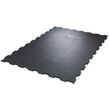 Svart, rektangul�r gummimatta med pusselkanter och halkskyddsm�nster, avsedd f�r golv i stall